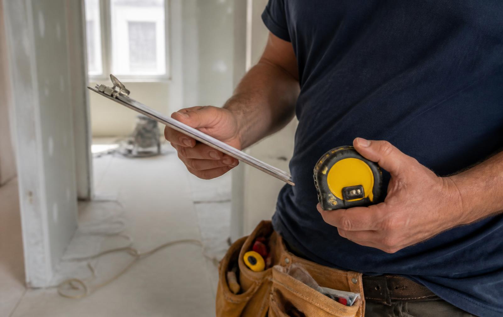 Calculator, notepad and a small model house used to budget repairs